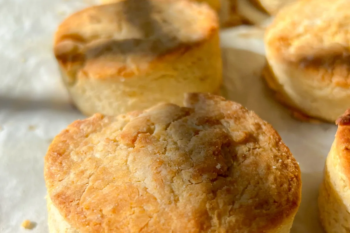 Tall, flaky homemade gluten-free buttermilk biscuits stacked on a plate showing their layers