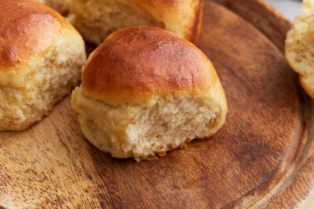 Golden homemade gluten-free dinner rolls showing their soft, fluffy interior